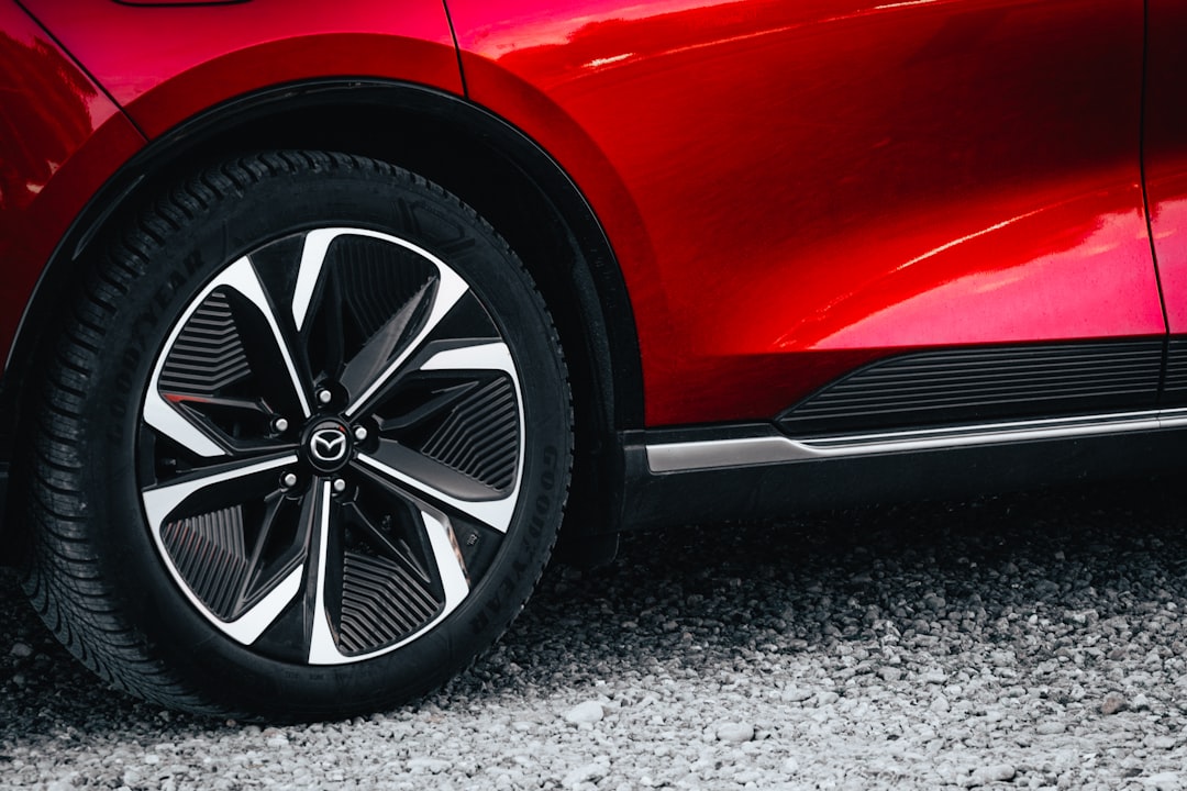a-red-cars-wheel-and-tire-on-a-gravel-surface-v7wpz0dldm0